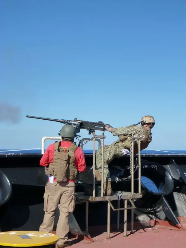 Members of the EST test the range of motion of the installed weapons mount. 